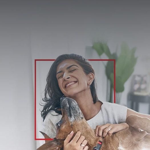 Mulher sorrindo abraçada ao seu cachorro