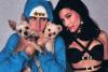 Justin Bieber com casaco azul segurando dois cachorros