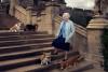 rainha elizabeth em escadaria posando com seus cachorros corgis